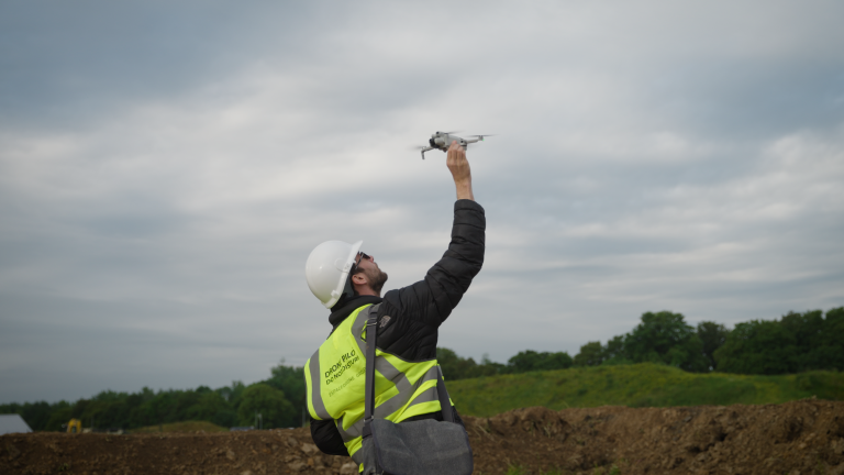 Opérateur de drone en action capturant des prises de vue aériennes pour un service professionnel.